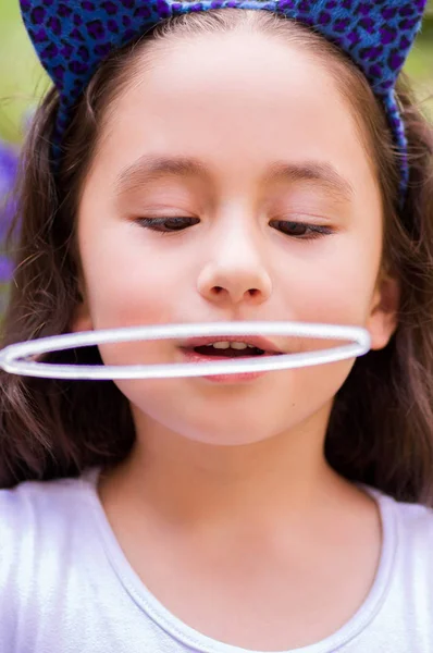 Retrato de gril pequeno feliz brincando com bolhas de sabão em uma natureza de verão — Fotografia de Stock