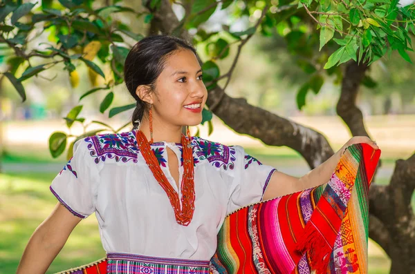 QUITO, ECUADOR - 30 AGOSTO 2017: Giovane indigena non identificata che indossa un abbigliamento tipico andino, tenendo in mano una coperta colorata nel parco — Foto Stock
