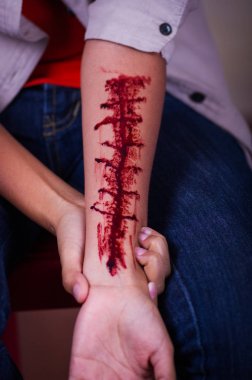 Kolunu kanama, bulanık bir arka plan ile bir genç depresif kadın yakın çekim