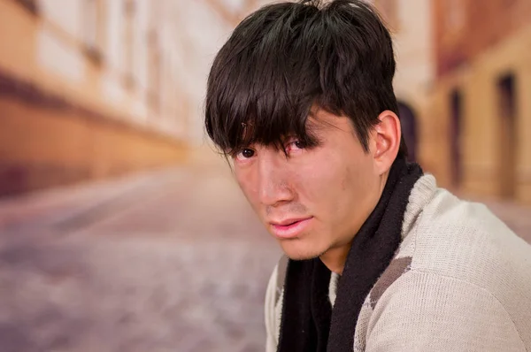 Portrait of a homeless young man in the streets, in a blurred background — Stock Photo, Image