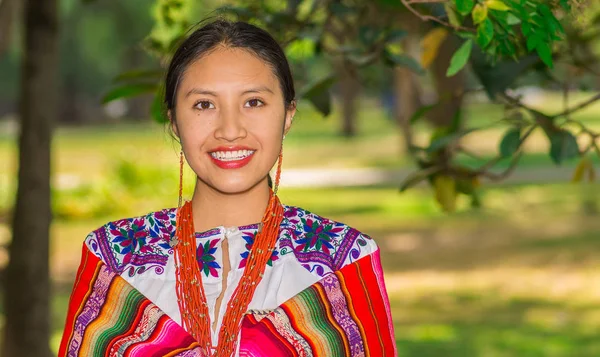 Inheemse jongedame dragen van een typische kleding van de Andes, die betrekking hebben op haar schouder met een kleurrijke deken in het park — Stockfoto