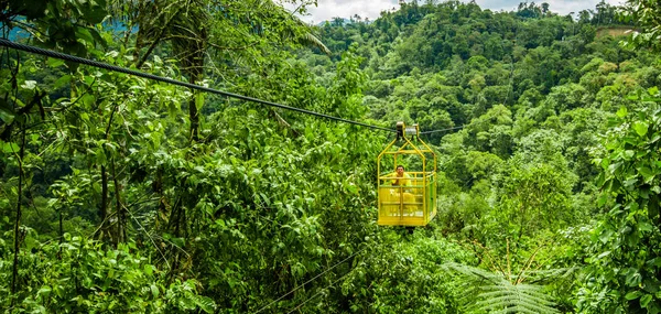 MINDO, ECUADOR - 27 DE AGOSTO DE 2017: Un hombre no identificado con un perro dentro del valle profundo de Tarabita, hasta 152 m sobre el suelo ubicado en Mindo, Ecuador — Foto de Stock