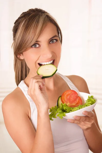 Mulher bonita vestindo uma camiseta branca comendo uma salada saudável — Fotografia de Stock