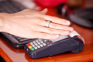 Ödeme akıllı bir ring kullanarak yeni teknoloji ile modern ödeme satın almak ve satmak ürünler hizmet ahşap bir masa üzerinde