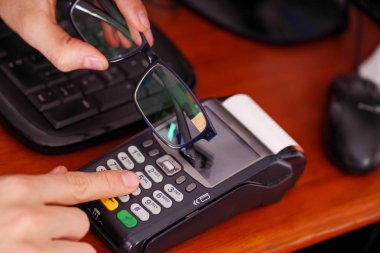 Yeni teknoloji ile modern ödeme ödemeler çip ile akıllı bir gözlükle ve datafast botton basarak satın almak ve satmak ürünler hizmet üzerinde ahşap bir masa, üstten görünüm