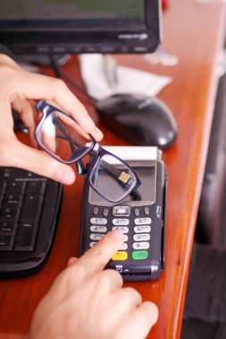 Yeni teknoloji ile modern ödeme ödemeler çip ile akıllı bir gözlükle ve datafast botton basarak satın almak ve satmak ürünler hizmet üzerinde ahşap bir masa, üstten görünüm