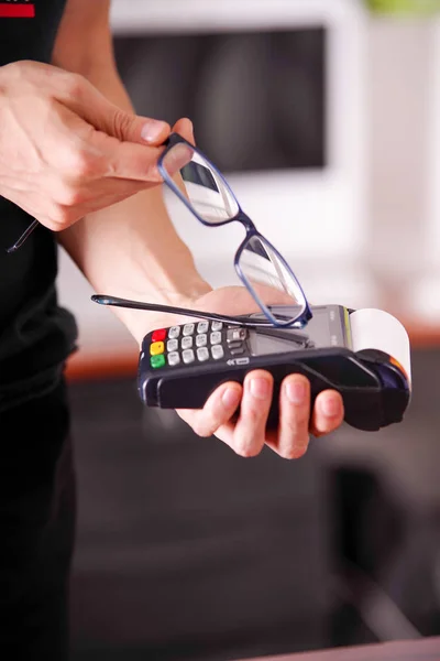 Close up de um homem de mão segurando um pagamento moderno com nova tecnologia de pagamentos usando um óculos inteligentes, comprar e vender produtos de serviço em um fundo turvo — Fotografia de Stock