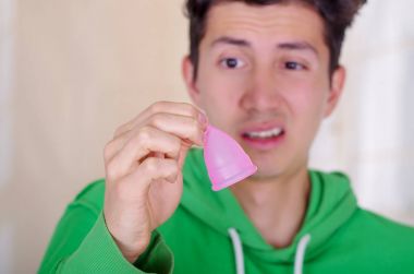 Bir adamın iğrenç bir yüz yapmak yakın süre arka plan bulanık elinde bir adet kaba holding