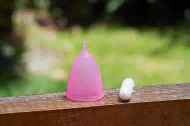 Kadın hijyen ürün - adet fincan arka plan bulanık pamuk tampon ile ahşap bir yapı üzerinde