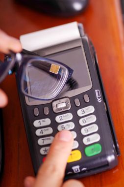 Yeni teknoloji ile modern ödeme ödemeler çip ile akıllı bir gözlükle ve datafast botton basarak satın almak ve satmak ürünler hizmet üzerinde ahşap bir masa, üstten görünüm