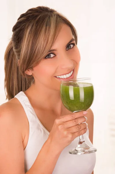 Bela jovem mulher sorridente vestindo uma camiseta branca e segurando uma salada saudável com uma mão e um copo de suco na outra mão — Fotografia de Stock