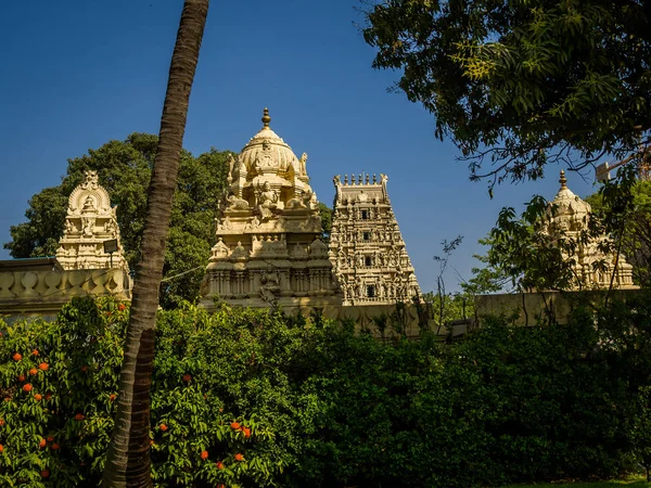 Beautiful view of a hindu temple with some sculptures around the building in a beautiful blue sky — Stock Photo, Image