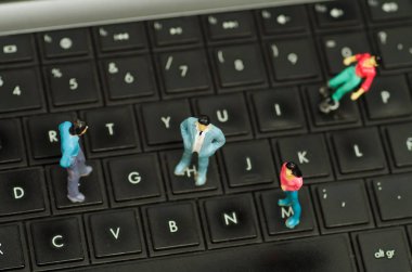 Minyatür küçük insanlar, bir bilgisayar klavye, bir arka plan bulanık üstten görünüm üzerinde arkadaş grubu