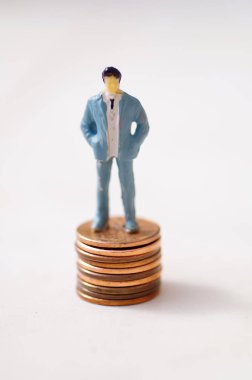 Minyatür küçük insanlar, adam beyaz bir arka plan bir sent yığını üzerinde poz