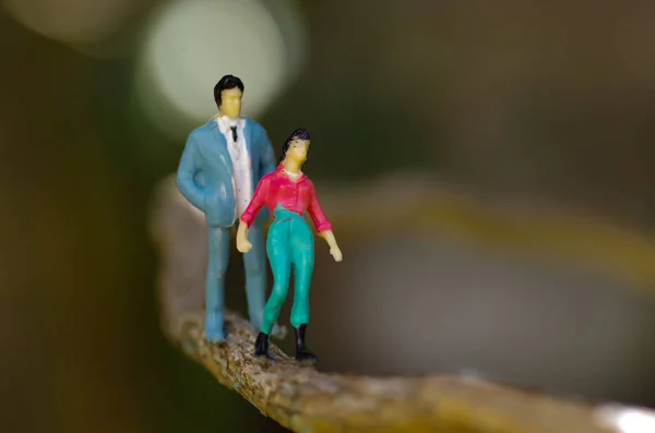 Närbild av en miniatyr småfolket par på utomhus, promenader i en gren i en suddig bakgrund — Stockfoto