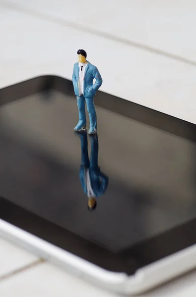 Miniature little people over a screen of a tablet, in a white background — Stock Photo, Image