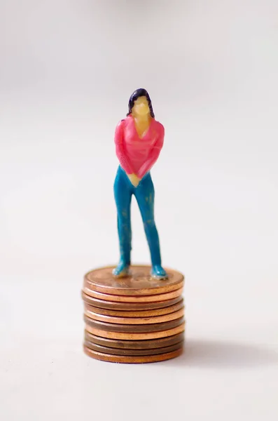 Pequeñas personas en miniatura, mujer posando sobre una pila de un centavo en un fondo blanco —  Fotos de Stock