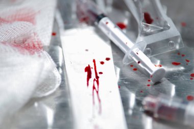 Gri arka plan üzerinde kan olan bir tıbbi müdahale sonra çeşitli tıbbi donatımı