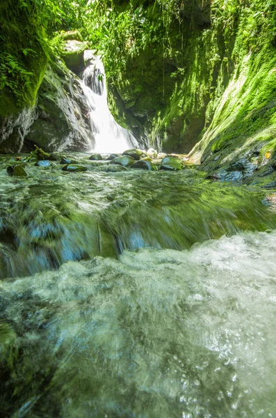 Beautiful small waterfall located inside of a green forest with stones in river at Mindo — Stock Photo, Image