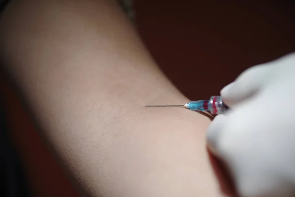 Close up van een naald injectie behandeling in haar arm — Stockfoto