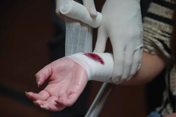 Nahaufnahme eines verletzten Handgelenks, bedeckt mit einem weißen Mullverband — Stockfoto