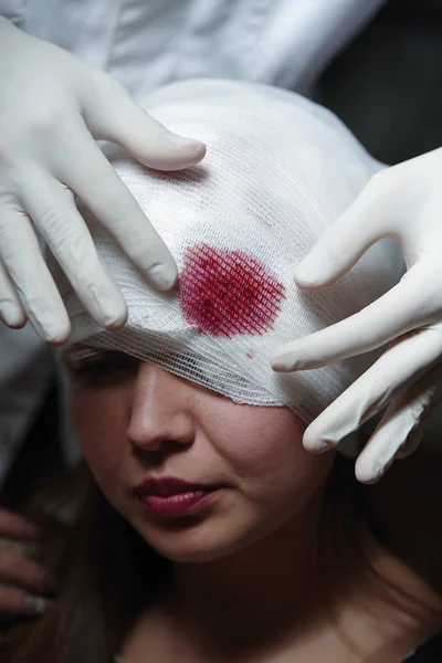 Portret van jonge oman met verwondingen aan haar hoofd met een gaas verband rond haar hoofd — Stockfoto