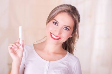 Bir adet pamuk tampon elinde tutan genç güzel gülümseyen kadın