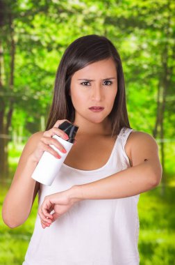 Güzel genç kadın bir spay, bulanık bir arka planda öldürmek için böcek üzerinde kullanma