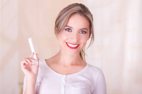 Young beautiful smiling woman holding a menstruation cotton tampon in her hand — Stock Photo, Image