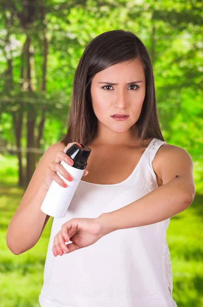 Güzel genç kadın bir spay, bulanık bir arka planda öldürmek için böcek üzerinde kullanma