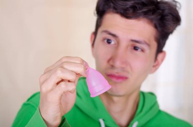 Bir adamın iğrenç bir yüz yapmak yakın süre arka plan bulanık elinde bir adet kaba holding