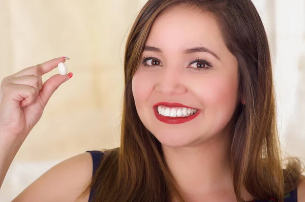 Portrait of a young woman holding in her hand a soft gelatin vaginal tablet or suppository, treatment of diseases of the reproductive organs of women and prevention of womens health — Stock Image Portrait of a young woman holding in her hand a soft gelatin vaginal tablet or suppository, treatment of diseases of the reproductive organs of women and prevention of womens health Stock Photo