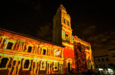 Quito, Ekvator Pichincha - 9 Ağustos 2017: Santo Domingo Kilisesi, kırmızı ve sarı magma, Quito ışık Festivali sırasında temsil eden cephesinde yansıtılan ışık gösteri kapat