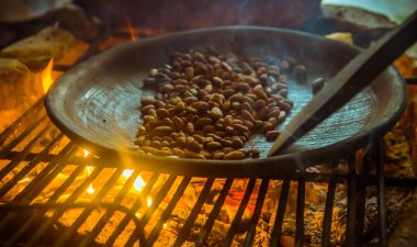 Kakao Bean metalik bir tepsi içinde kakao çekirdekleri Kavurma, bir odun sobası üzerinde yakın çekim