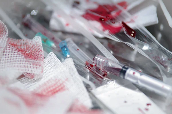 Varios equipos médicos después de una intervención médica, con sangre sobre fondo gris —  Fotos de Stock