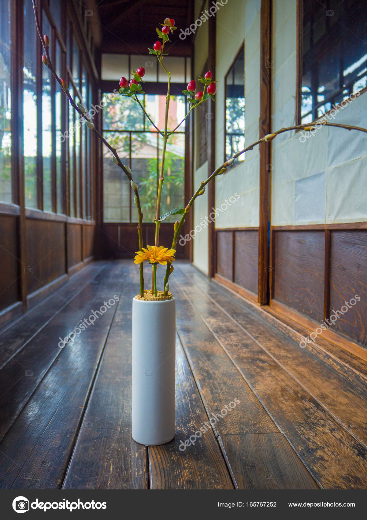 Close Up Of A Flower Vase With A Yellow Flower And Red Branch At