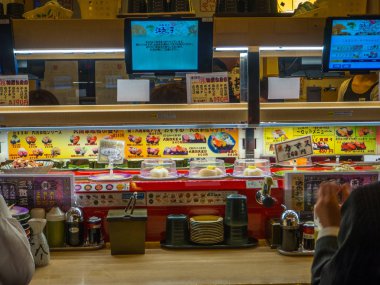 Tokyo, Japonya -28 Haziran 2017: yakın çeşitli japanesse yiyecek bir tablo üzerinde bir kaitenzushi Konveyör bant suşi restoran Tokyo içinde menü ile bir ekran ile