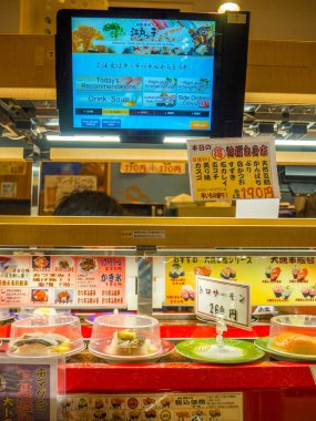 Tokyo, Japonya -28 Haziran 2017: yakın çeşitli japanesse yiyecek bir tablo üzerinde bir kaitenzushi Konveyör bant suşi restoran Tokyo içinde menü ile bir ekran ile