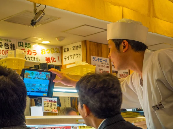 日本东京-28 Jun 2017： 身份不明的人在一张桌子，在 kaitenzushi 输送机皮带寿司餐厅，在东京吃什锦的日本食品 — 图库照片