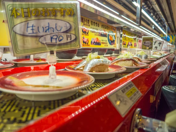 TOKYO, JAPAN-28 JUN 2017: Tutup berbagai macam makanan japanesse di atas meja, di dalam restoran sushi konveyor kaitenzushi di Tokyo — Stok Foto