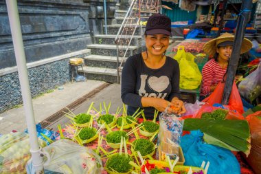 Bali, Endonezya - 08 Şubat 2017:'de bir tabloda Endonezya Denpasar şehir bir pazarda yapılmış bir kutusunun içinde çiçek tanzimi yapraklar kimliği belirsiz bir kadın yapmak