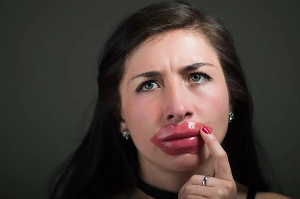 Mujer hermosa chica natural aplicando una máscara de labios de color rosa, tratamientos de spa. Cosmetología en un fondo oscuro —  Fotos de Stock