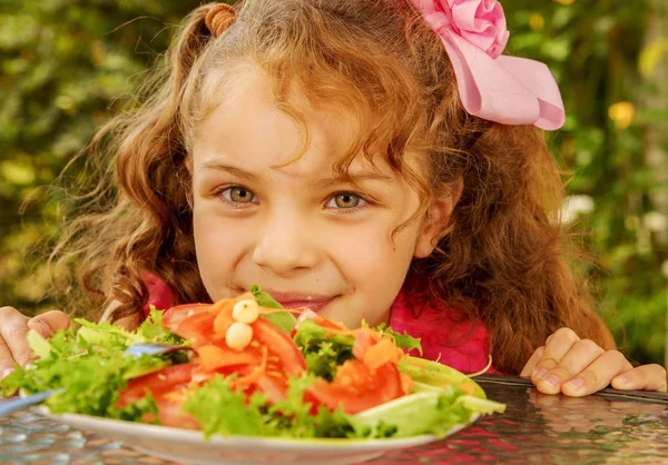 Close up of beautiful girl, watching a healthy salad, in a garden background — Stock Photo, Image