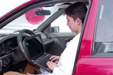 Yakışıklı delikanlı mekanik motor işlevleri kontrol etmek için cep telefonu uygulama sonuçlarını kontrol etmek için bir bilgisayar kullanın