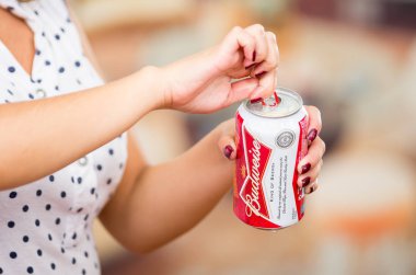Quito, Ekvator - 06 Mayıs 2017: serinletici bir Budweiser bira bulanık arka planda, vintage etkisi açılış genç kadın