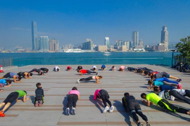 Hong Kong, Çin - 26 Ocak 2017: Kalabalık bir Sity şehrin arka plan olarak Hong Kong ile sabah Tai Chi egzersiz yapan insanlar. Arazi 1,104 km ve 7 milyon nüfusu ile