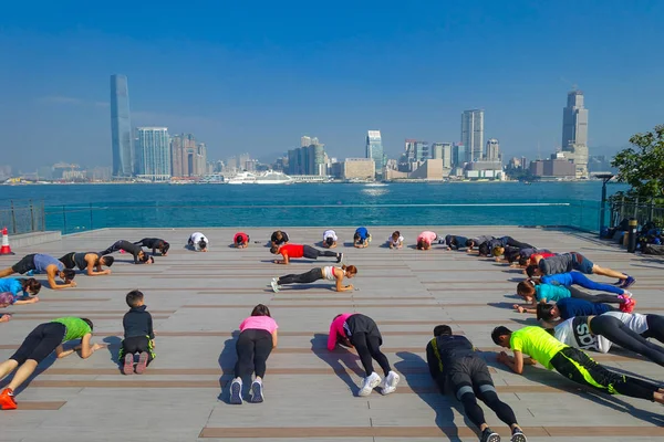 Лозова, Україна - 26 січня 2017: Натовп людей робити фізичних вправ Тайцзицюань вранці, з downton міста Гонконгу як фон. З землі 1 104 км і населення 7 мільйонів — стокове фото
