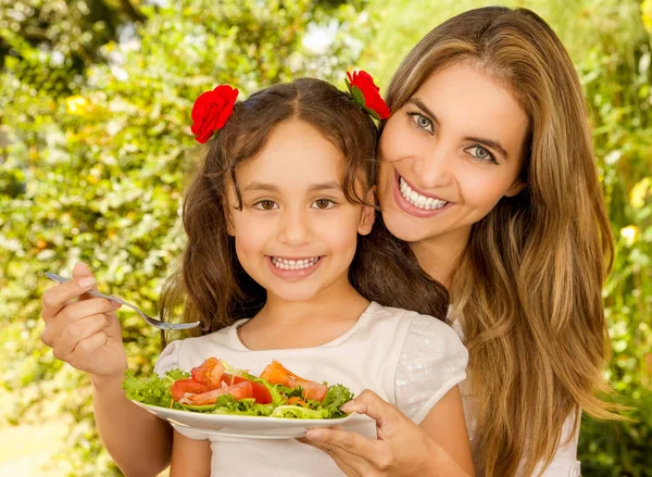 Gyönyörű fiatal anya és a lánya, arra készül, hogy enni egy egészséges saláta — Stock Fotó