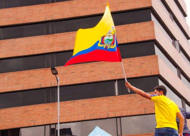 Quito, Ekvator - 7 Nisan 2016: Tanımlanamayan adam başkan adayı Guillermo Kement ve hükümet protesto anti sırasında gazeteciler Shyris caddede destekleyen Ekvador bayrak ile