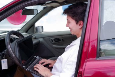 Yakışıklı delikanlı mekanik motor işlevleri kontrol etmek için cep telefonu uygulama sonuçlarını kontrol etmek için bir bilgisayar kullanın